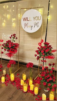 flowers and candles are arranged on the floor in front of a sign that says will you marry me?