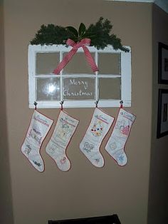 christmas stockings hanging on the wall next to a window