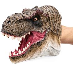 a hand holding a fake dinosaur head with its mouth open