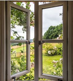 an open window with the view of a lush green field