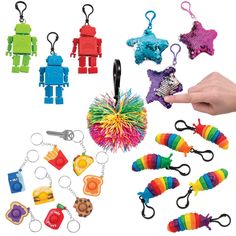 a hand holding a bunch of assorted toy items in it's palm next to some key chains