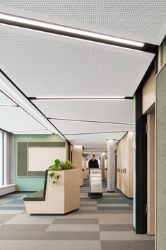 an office hallway with checkered flooring and planters