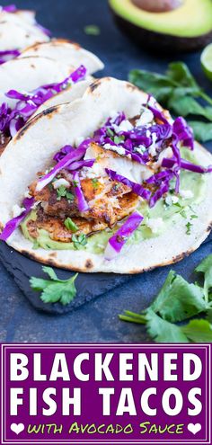 two fish tacos with cabbage and avocado on the side, next to an avocado