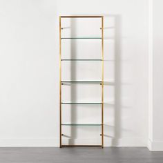 an empty shelf with glass shelves on it in front of a white wall and wooden floor