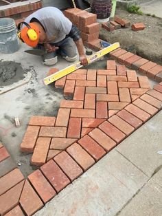 a man laying bricks on the ground