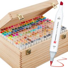 a wooden box filled with lots of different colored crayons next to a marker