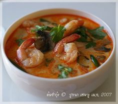 a white bowl filled with soup and shrimp