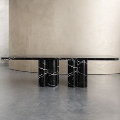 two black and white marble tables in an empty room