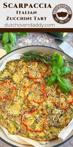 an image of a pizza with tomatoes and herbs on it in a pan next to basil leaves