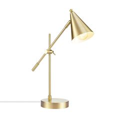 a gold desk lamp on a white surface with the light turned on and one arm extended