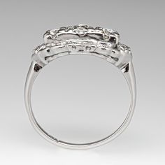 This beautiful vintage ring is centered with one (1) old European cut diamond set into a four-prong setting. The center stone is flanked to each side by one (1) round brilliant cut diamond set into a four-prong setting. The center stones are bordered with twelve (12), bead set, round single cut diamonds. The ring measures 9.7mm at the top, rises 5.1mm above the finger, tapering to 1.7mm wide and 1.1mm thick at the base of the shank. It is currently a size 8. Classic Three Stone Cluster Ring For Formal Occasions, Brilliant Cut Cluster Ring With Round Stone For Anniversary, Brilliant Cut Cluster Ring For Anniversary, Anniversary Cluster Ring With Brilliant Cut Round Stone, Formal Fine Jewelry Three Stone Cluster Ring, Classic Formal Three Stone Cluster Ring, Elegant Three Stone Cluster Ring For Formal Occasions, Rose Cut Diamond Ring With Round Band, Vintage White Gold Diamond Ring With Accents