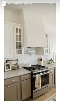 a kitchen with an oven, stove and pictures hanging on the wall in it's corner