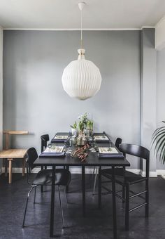 a dining room table with chairs and a lamp hanging over it