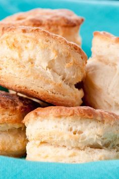 biscuits are piled on top of each other in a blue bowl with a green cloth