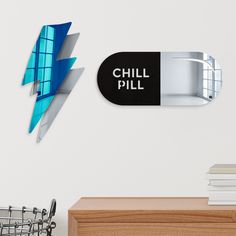 there is a sign that says chill pill on the wall next to a desk with books