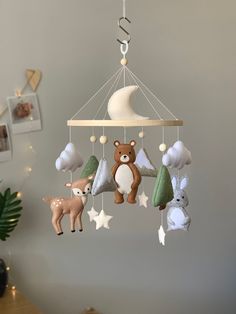 a baby mobile with stuffed animals hanging from it's sides and the moon in the background