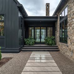 the entrance to a modern home with stone steps