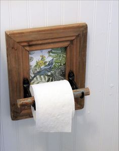 a toilet paper roll is hanging from a wooden frame