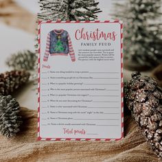 a christmas family eud game sitting on top of a table next to pine cones