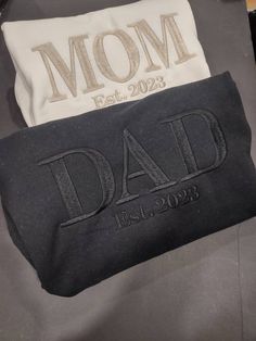 two black and white bags with the words mom and dad printed on them, sitting next to each other