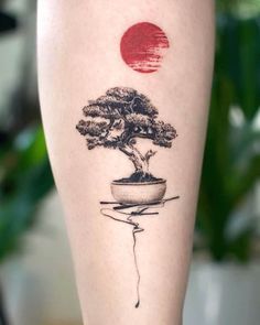 a small bonsai tree tattoo on the right leg, with a red sun in the background