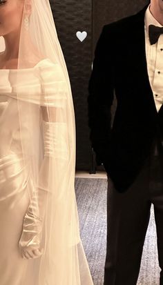 a man and woman in wedding attire standing next to each other