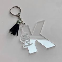 a keychain with the letter v on it and a tassel hanging from it