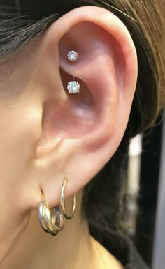 a close up of a person's ear with two small hoops on it