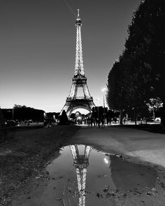 black and white photograph of the eiffel tower with its reflection in the water