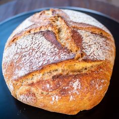 a loaf of bread sitting on top of a blue and black plate with powdered sugar