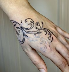 a person's hand with a tattoo design on the middle of their left hand