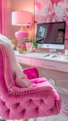 a pink chair sitting in front of a computer desk