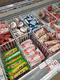 a grocery store display filled with lots of different types of snacks and candy bars in bins