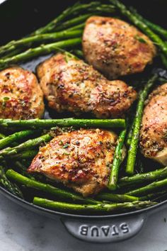 chicken and asparagus cooking in a skillet