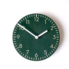 a green clock with white hands and numbers on the face is shown against a white background