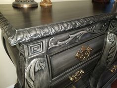 an ornate black dresser with gold handles and knobs