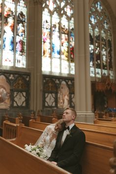 a bride and groom sitting in the pews of a church