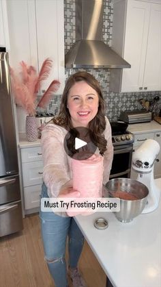 a woman standing in a kitchen holding a pink blender and mixing bowl with the words must try frosting recipe