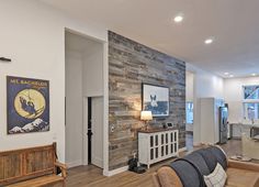 Gray reclaimed wood accent wall in an open floor plan room. Loves Shiplap Wood Planks, Wood Planks For Walls, Reclaimed Wood Accent Wall, Reclaimed Wood Paneling, Wood Plank Walls, Popular Interior Design, Wood Accent Wall, Accent Walls In Living Room, Tv In Bedroom