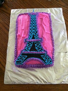 a cake that is shaped like the eiffel tower with pink frosting and blue icing