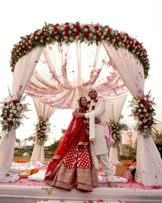 two people standing in front of a wedding arch