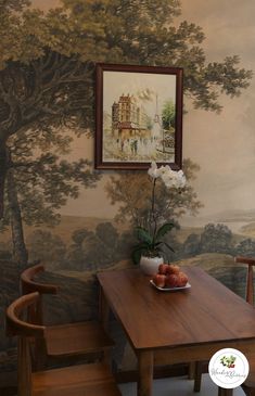 a wooden table sitting in front of a wall with a painting on it's side