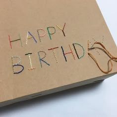 a birthday card with the words happy birthday written on it and some string attached to it