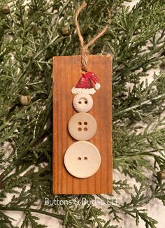 a wooden ornament with two buttons attached to it