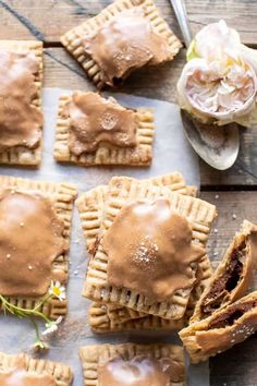 homemade peanut butter and jelly crackers on a wooden table with flowers in the background