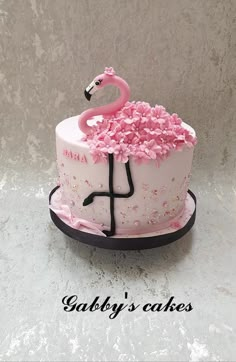 a cake decorated with pink flowers and a flamingo on top