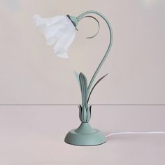 a light that is on top of a table with a flower in the middle of it