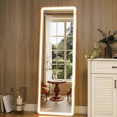 a large mirror sitting on top of a wooden floor next to a table and chair