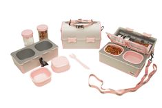 an assortment of pink and white items including a lunch box, utensils and spoons