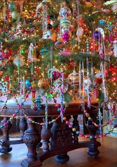 a christmas tree with ornaments hanging from it's branches and decorations on the top